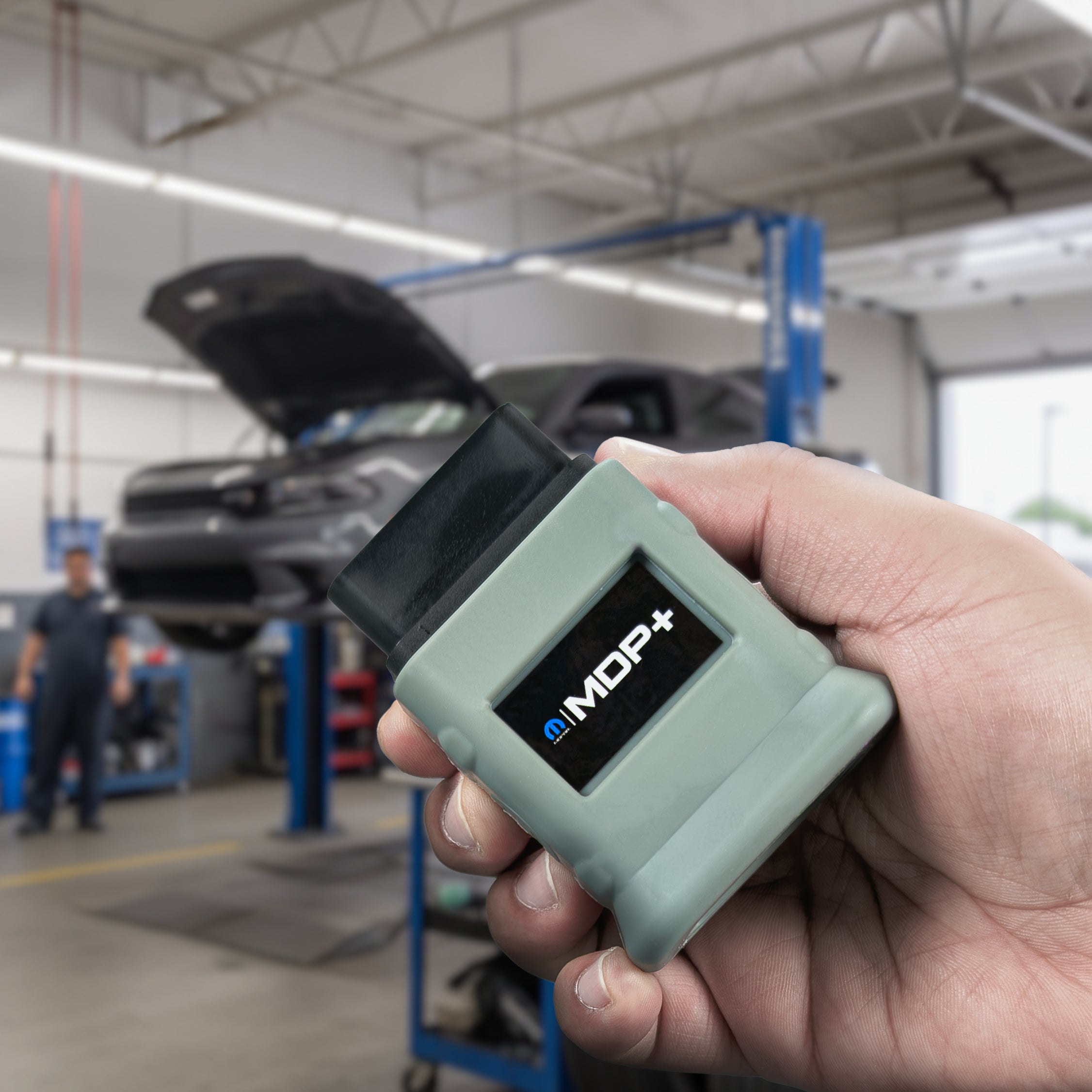 MDP+ In a mechanic shop where a dodge charger is suspended on a lift.